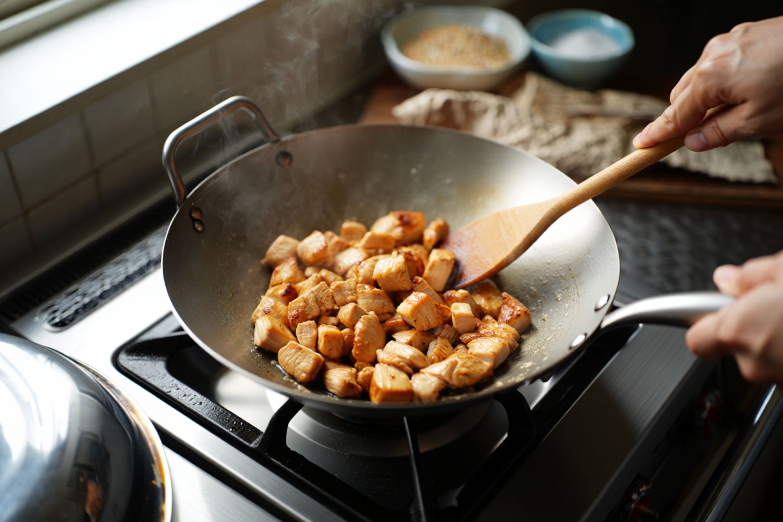Cuisson du poulet dans un wok à feu vif