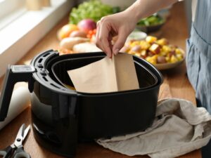 Femme qui met du papier de cuisson dans un air fryer